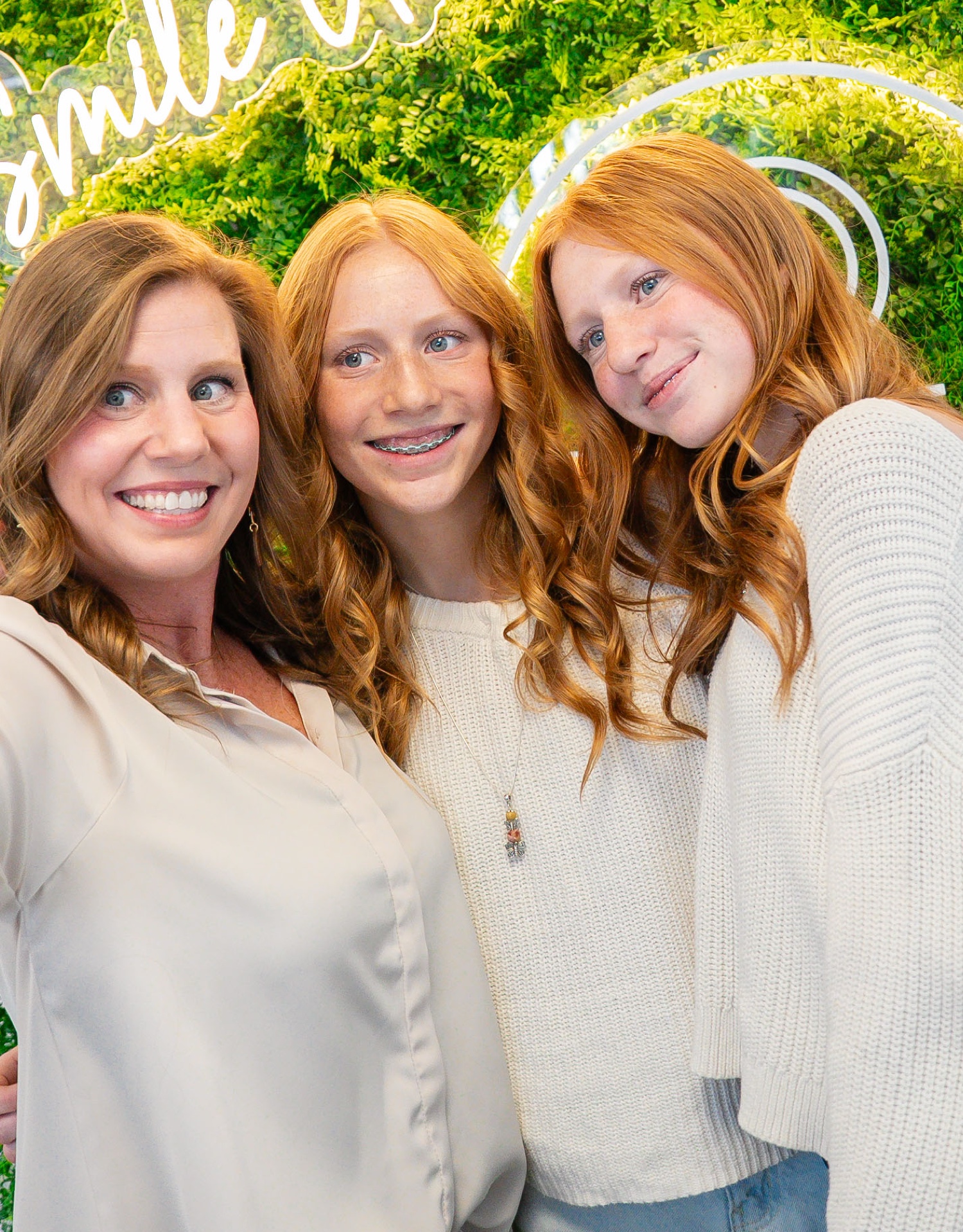 Two young patients and their parent smiling