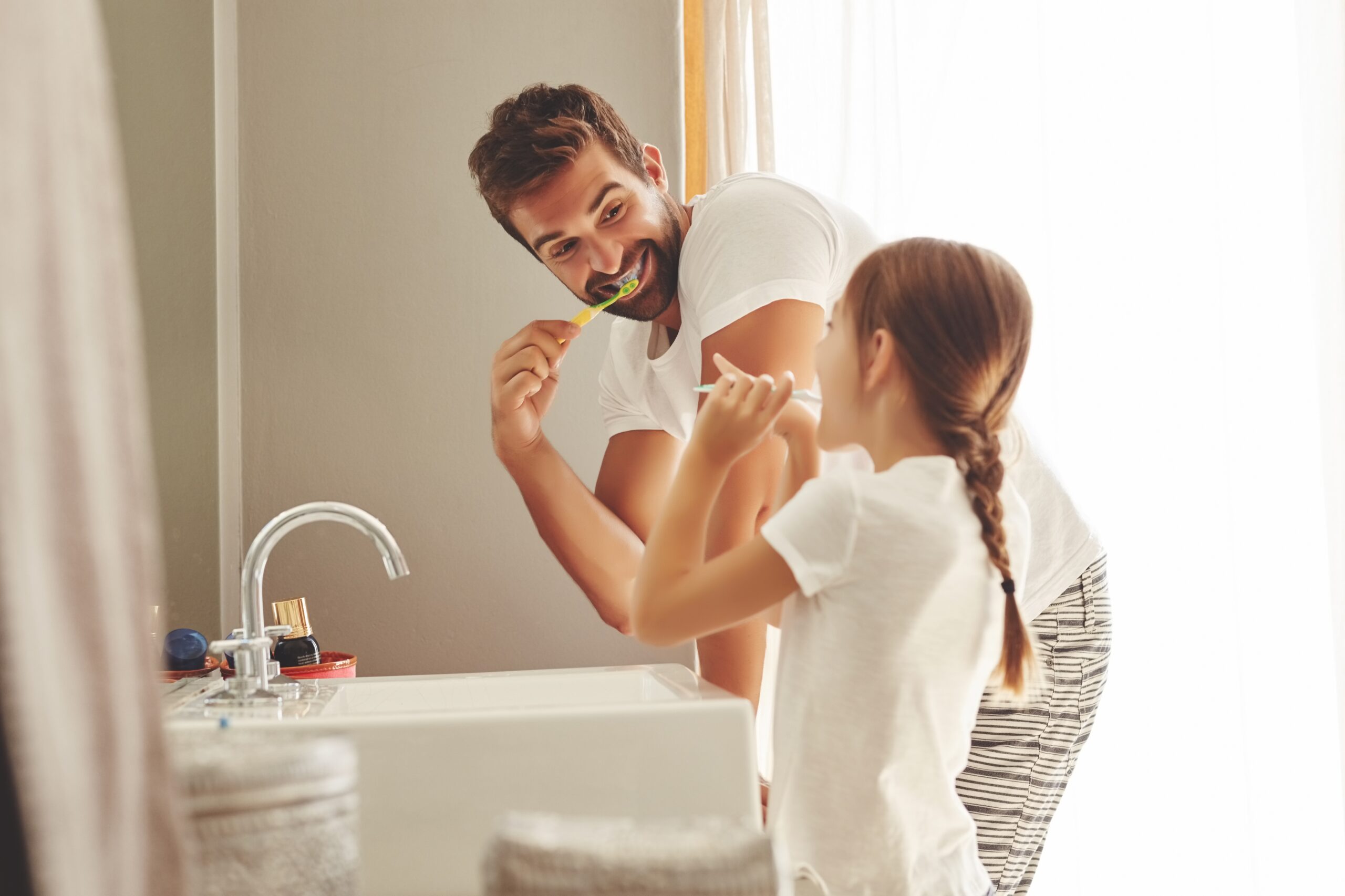 Dental,Care,,Father,With,Daughter,Brush,Their,Teeth,And,In braces littleton