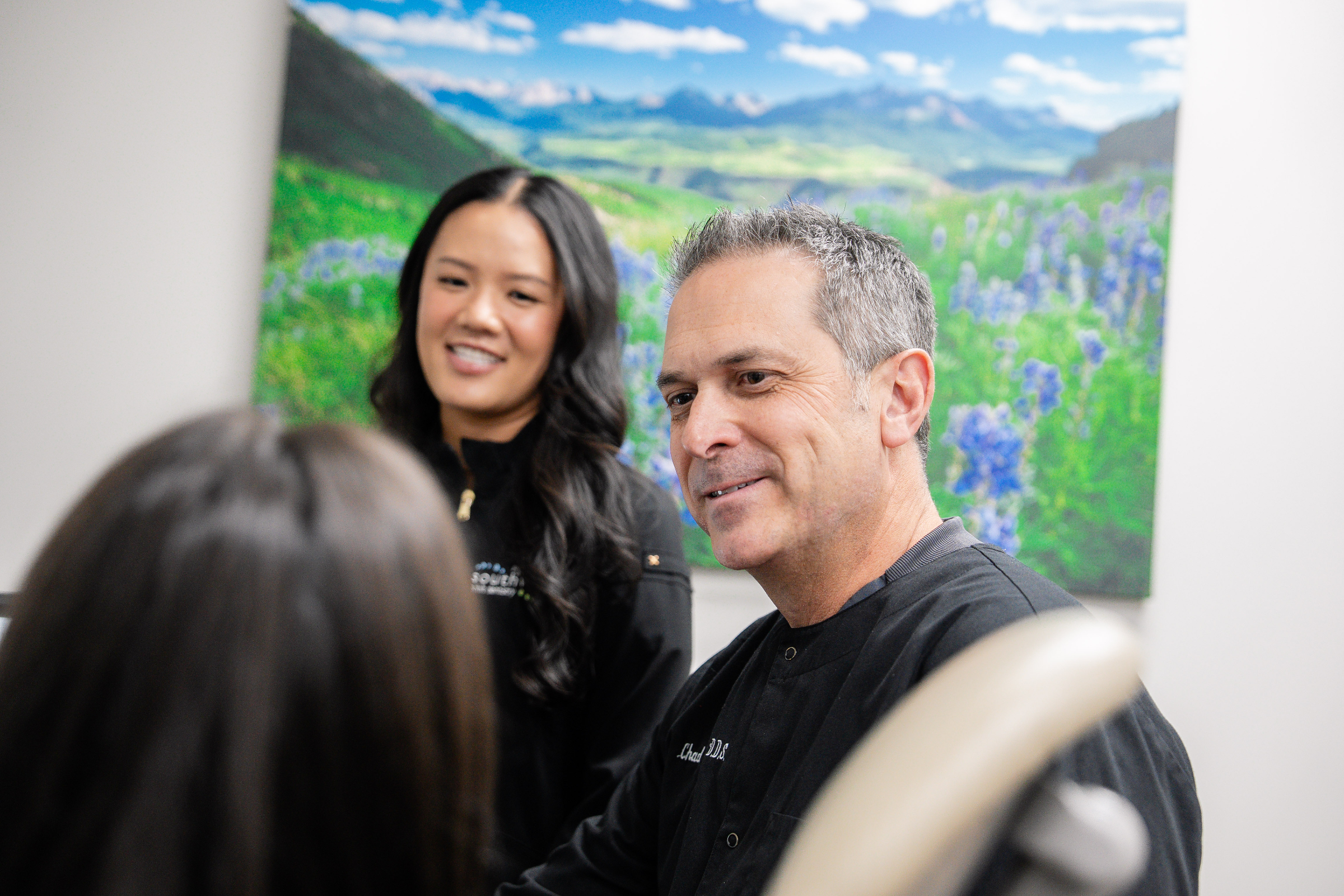 Dental consultation at Southwest Pediatric Dentistry & Orthodontics, featuring orthodontist and staff in a comfortable setting with scenic nature backdrop.